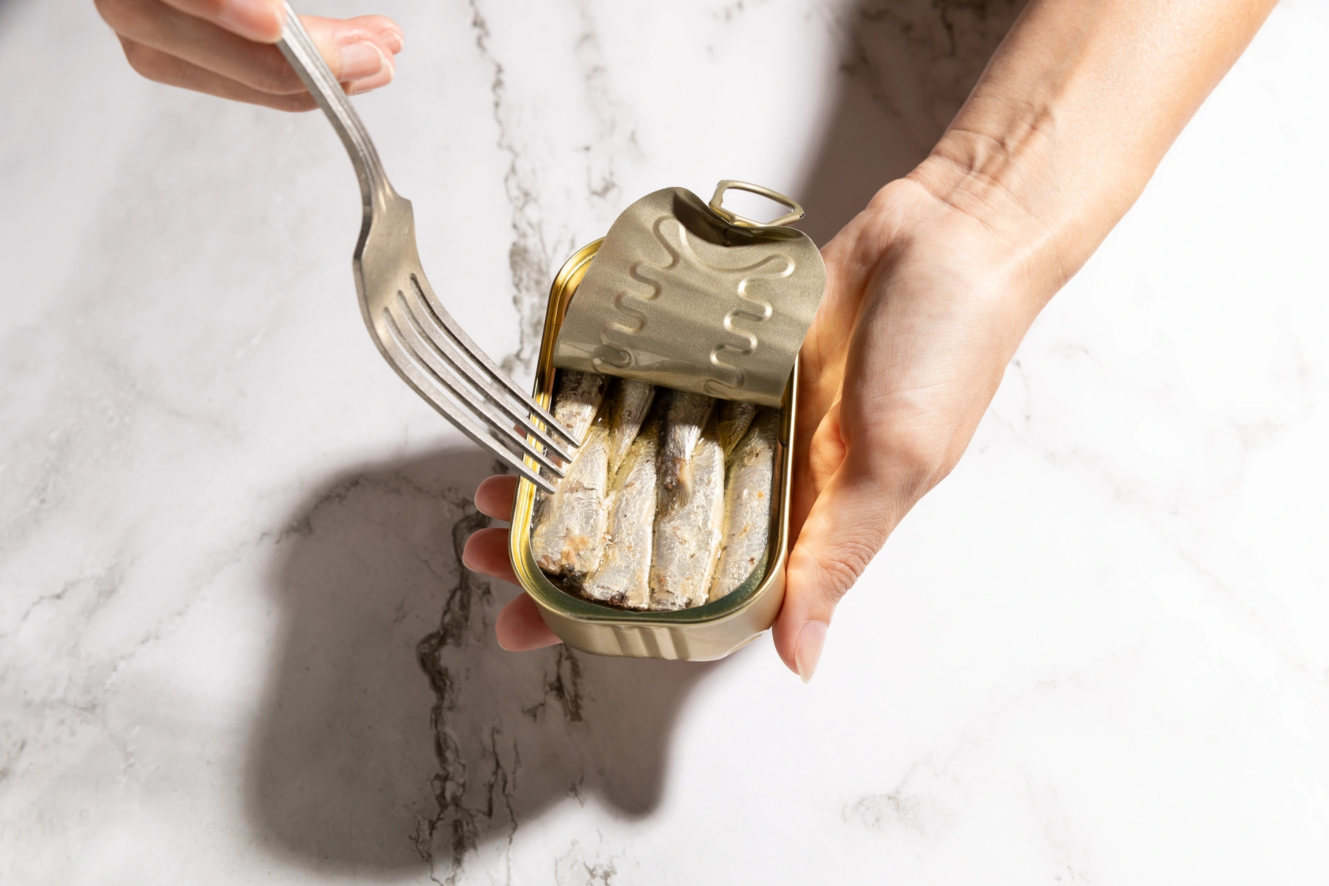 Colorful tins of sardines and other seafood stacked on yellow shop shelves